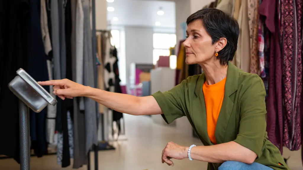 Mulher pesando caixas de roupas, destacando a importância do controle de estoque.